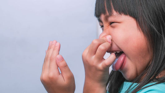 barn håller för näsan och grimaserar