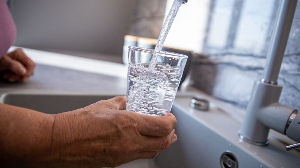 äldre dam håller en rent glas med vatten