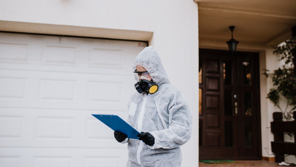 kvinna utanför hus med skyddsutrustning på 